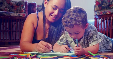 A mother is drawing with crayons in a notebook together with her son Stock-Footage 170729360