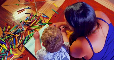 A mother is drawing with crayons in a notebook together with her son Stock-Footage 170729848