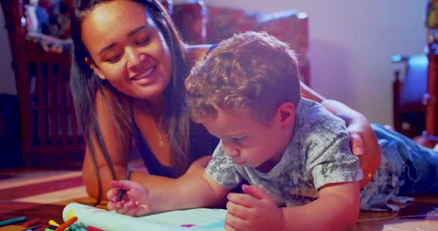 A mother is drawing with crayons in a notebook together with her son Stock-Footage 170730638