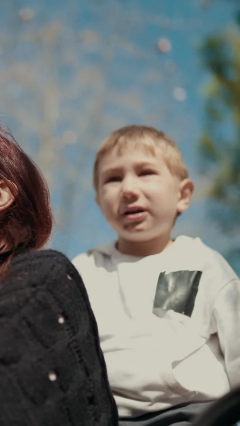 Mother drinking orange juice with her son in the park Stock Footage 327128902