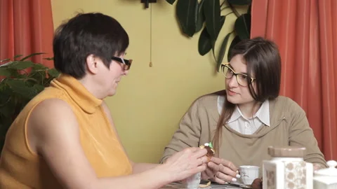 The mother eats the cake and her daughter drinking coffee. Kitchen, laughter Stock Footage 105100972