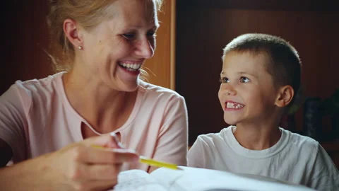 The mother is engaged in teaching her son using a book. Stock Footage 279416596
