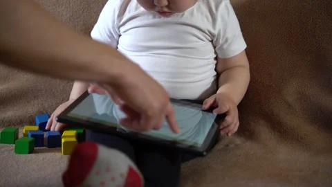 Mother explaining to a small child how to use a tablet computer Stock Footage 237607772