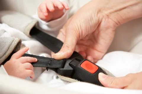 Mother Fastening Safety Clip On Baby Seat Stock Photos