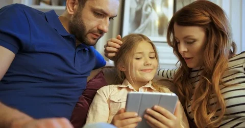 Mother, father and daughter using tablet, playing games and having fun. Happy Stock Footage 74284586
