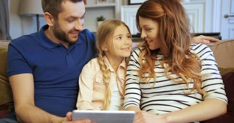 Mother, father and daughter using tablet, playing games and having fun. Family Stock Footage 74286283