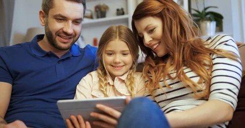 Mother, father and daughter using tablet, playing games and having fun. Family Stock Footage 74286620