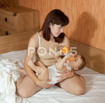 Mother feeding baby with bottle Stock Photos