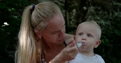 Mother Feeding Her Baby Boy With a Spoon. Mother Giving Food to Her Adorable Stock Footage
