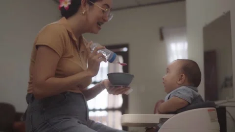 Mother feeding her infant son at home Video stock 341892432