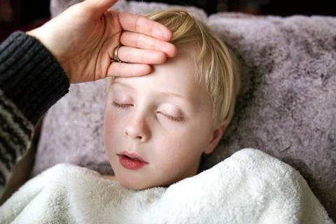 Mother Feeling Forehead Temperature of Sleeping Child who is Home Sick With F Stock Photos