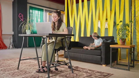 Mother freelancer can work when her child is engaged with tablet pc Stock Footage 232256364