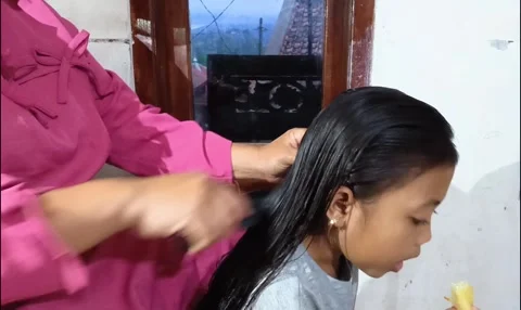 Mother gently combing and styling her daughter's long. Stock Footage 321941163