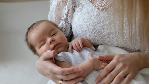 Mother gently holding and lulling baby girl. Newborn Baby sleep in mother's arms Vídeos de archivo 107553010