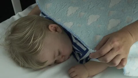 Mother gently stroked the sleeping baby's head and hair in a child's cot crib Stock Footage 149237226
