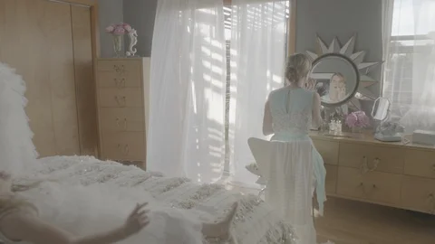 Mother getting ready while daughters playing on bed at home Stock Footage 99998737