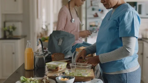 Mother getting ready for work packing daughters lunch teenage girl going to Stock Footage 113254349