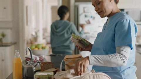 Mother getting ready for work packing daughters lunch teenage girl going to Stock-Footage 113254359