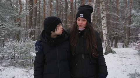 A mother gives her child advice during a supportive walk in a winter forest. Stock Footage 311886853