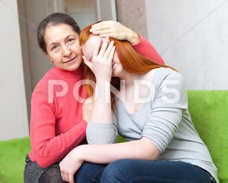 Mother gives solace to crying daughter Stock Photos