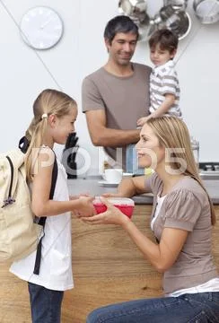 Mother giving her daughter the school lunch Stock Photos