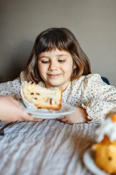 Mother giving piece of easter cake to child girl. Foto stock