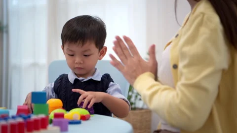 Mother guiding a child while playing educational toys 스톡 동영상 339561162