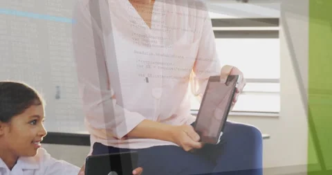 Mother guiding daughter using tablets displaying code overlay for technology Stock Footage 307429352