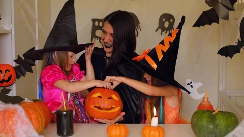 A mother in the guise of a devil and daughters dressed as witches Stock Footage 289732326