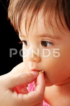 Mother hand feeding her little baby Stock Photos