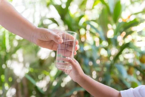 Mother handed the glass to the child. Stock Photos