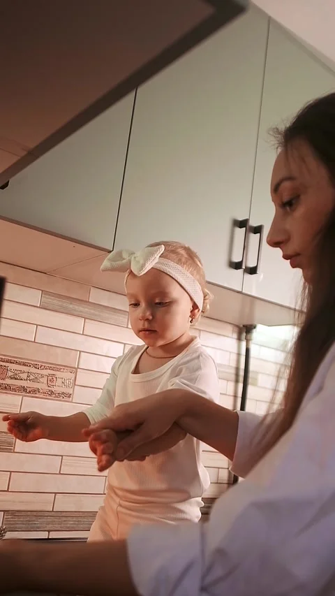 Mother hands her daughter in the kitchen after cooking a holiday dinner together Stock Footage 288450737