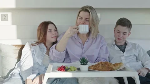 Mother having breakfast in bed with her childrens at mothers day. family Stock Footage 233474708