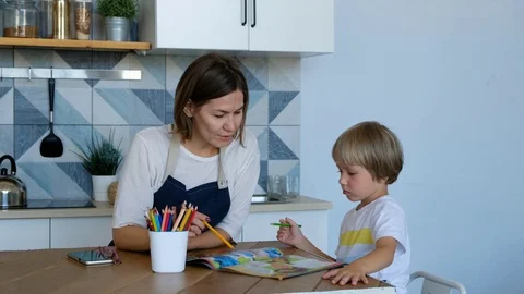 Mother help her son to do homework at kitchen room. People with family Stock Footage 116657563