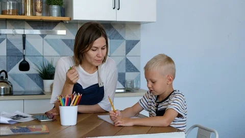 Mother help her son to do homework at kitchen room. People with family Vídeos de archivo 116657601