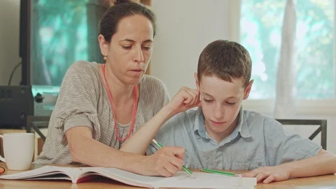 Mother helping her son to do his homework at home Stock Footage 95240854