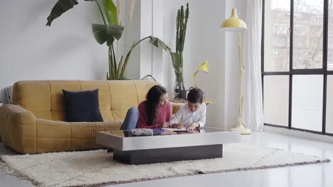 Mother helping her son to do homework for school Spbi. Child writing notes in Stock Footage 150664714