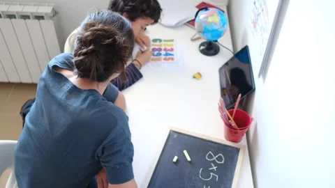 Mother helping her son do homework back to school. Video stock 270484136