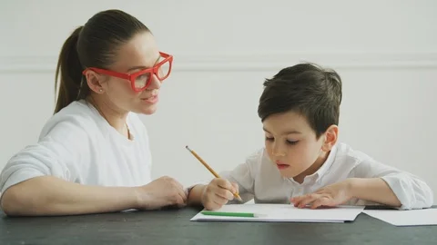 Mother helping her son with homework at home Stock Footage 106314780