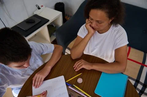 Mother helping her son with math homework at kitchen table Stock Photos