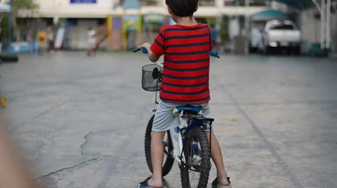 Mother helping her son training in bicycle Stockbeeldmateriaal 47750924