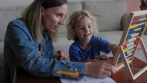 Mother helping son with school homework inside home living room - Education  Stock Footage 239784662