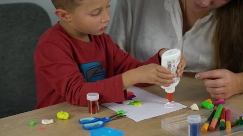 Mother helping young boy with creative craft activity at home Vídeos de archivo 341328425
