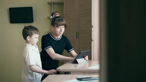 Mother helps her son do homework for school, uses a tablet computer. Stock Footage 105101691