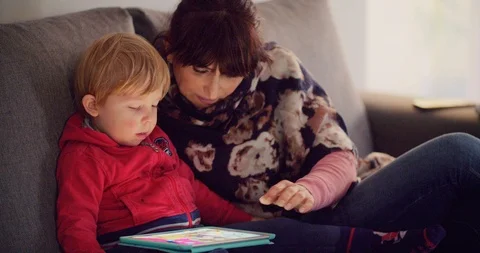 Mother with her son using tablet on sofa at home Stock Footage 103387445