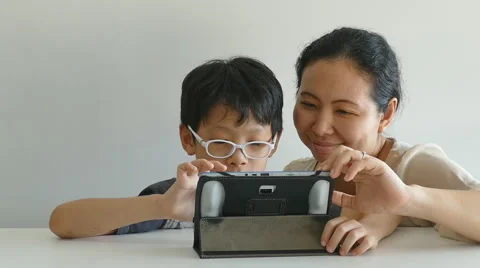 Mother with her son web surfing on digital tablet Stock Footage 56606531