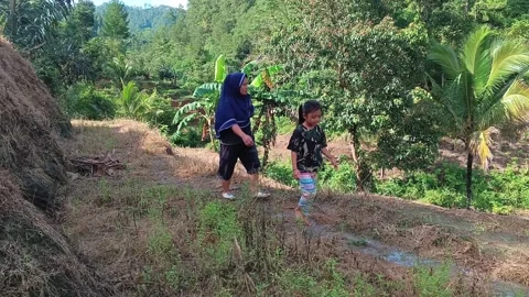 Mother in hijab walking side by side with her daughter. 스톡 동영상 321933925