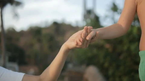Mother holding hand son walking on palm on tropical beach. Close up of hands. Stock Footage 61968341