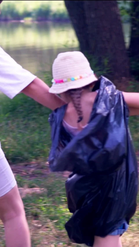 Mother Holding Hands with Two Daughters While Cleaning Plastic Waste from Stock Footage 340577410