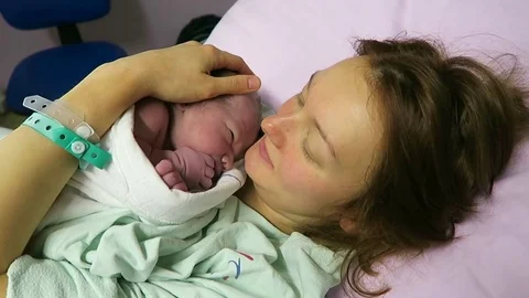 Mother holding her newborn baby child after labor in a hospital. Stock Footage